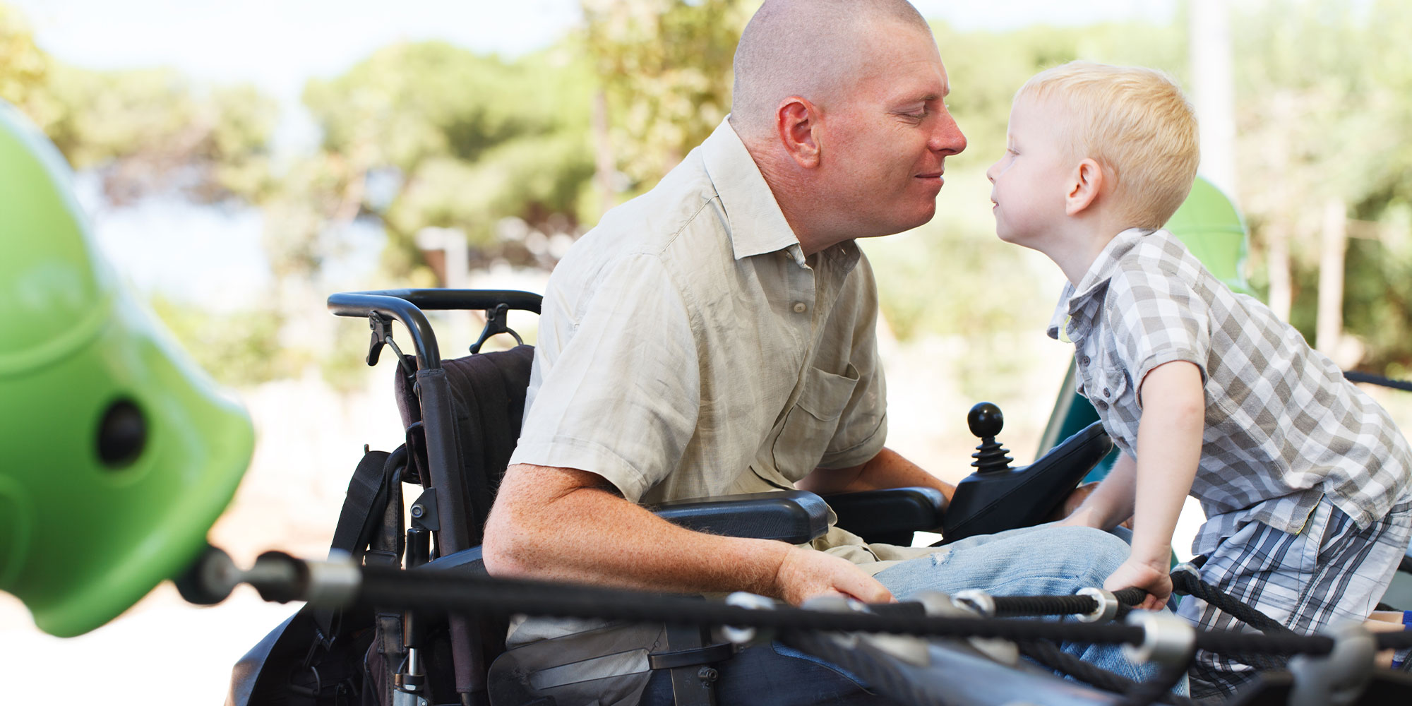 Parent in wheelchair smiling with child