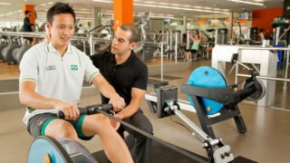 Researcher working with a client in a gym environment