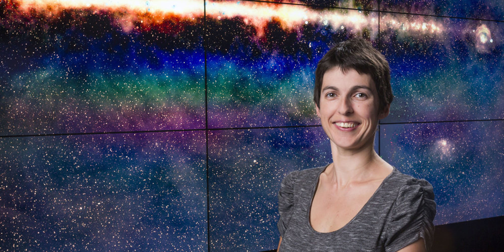 Researcher Natasha Hurley standing in front of display of space